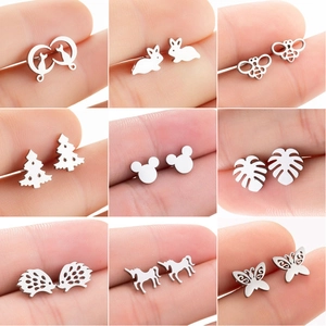 Macro shot showing diverse stainless steel stud earrings including laser-cut nature motifs