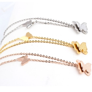 Makroansicht doppellagiger Schmetterlingsketten in Silber, Gold und Roségold-Finish