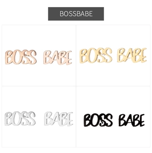 Detalle de pendientes Boss Babe con acabados en oro rosa, dorado, plateado y negro mate