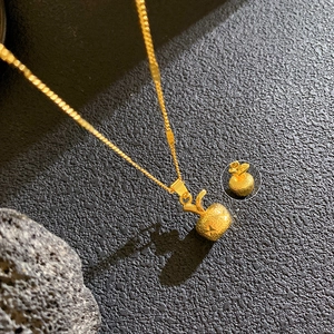 Elegant gold apple pendant necklace with brushed matte finish and star pattern accents