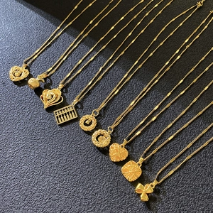 Collection of golden dreamcatcher and apple pendants on minimalist necklaces