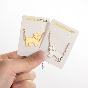 Pulseras con colgante de perro en oro y plata sobre tarjetas de acero inoxidable