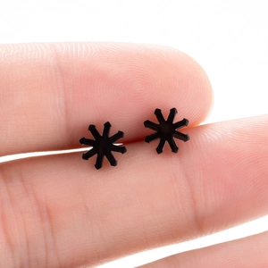 Vue macro d'une boucle d'oreille étoile noire minimaliste montrant sa taille compacte