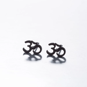 Gros plan de boucles d'oreilles clous Om noir mat avec finition lisse et bords nets
