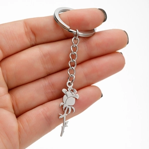 Silver stainless steel rose flower keychain charm held by hand on white background