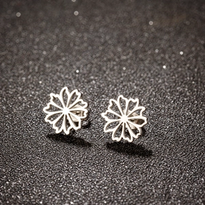 Vue macro de boucles d'oreilles pétales évidés en argent avec finition acier poli