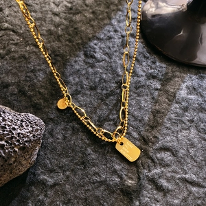 Double-layered gold chain necklace with queen coin pendant and rectangular ID tag