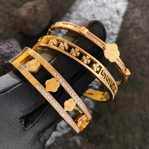 Gold titanium steel bracelet set featuring clover flower designs and zircon inlay