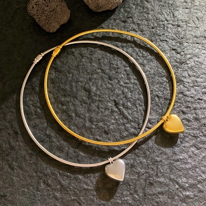Elegante Herzanhänger Halsketten in Gold und Silber mit Schlangenketten auf dunklem Stein