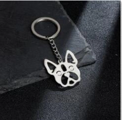 Detailed view of silver stainless steel pug dog pendant keychain on dark stone background