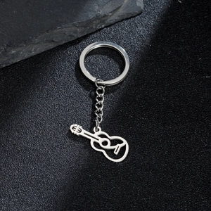 Porte-clés guitare en acier inoxydable poli sur un fond noir avec texture