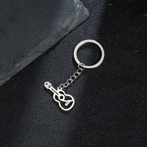 Porte-clés guitare poli en acier inoxydable sur fond noir mat et pierre