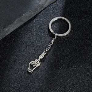 Macro detail of silver skeleton hand holding a rose pendant on black leather base