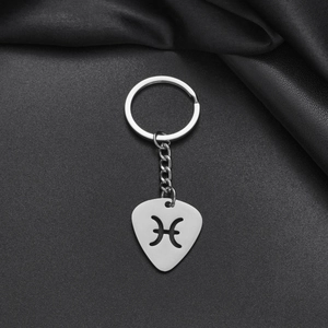 Macro detail of silver stainless steel keychain featuring a hollow Pisces zodiac charm