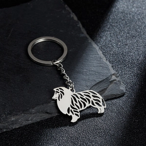 Polished stainless steel dog silhouette keychain featuring a collie outline on a dark stone