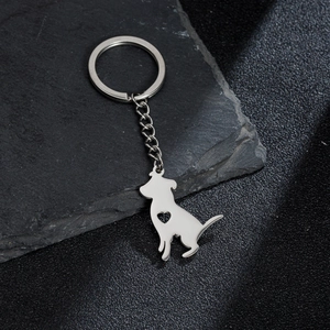 Llavero de perro metálico plateado con diseño de corazón calado sobre fondo de piedra