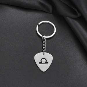 Polished stainless steel Libra zodiac keychain with guitar pick shape on black fabric