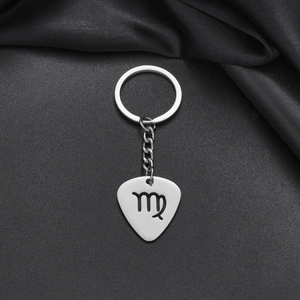 Macro shot of silver stainless steel guitar pick keychain with Virgo zodiac engraving