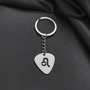 Detailed macro view of silver stainless steel Leo zodiac keychain with hollow guitar pick design