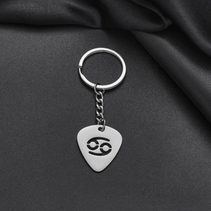 Detail of silver stainless steel guitar pick keychain with hollow Cancer zodiac symbol
