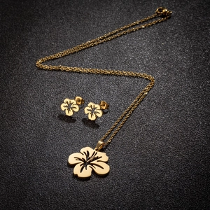 Ensemble de bijoux fleurs dorées épuré avec collier et boucles d'oreilles clous