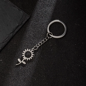 Macro detail of sunflower pendant keychain with hollow lines in polished silver finish
