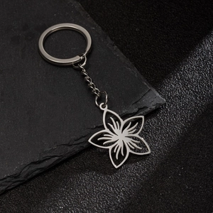 Minimalist silver stainless steel keychain with hollow flower petal pendant on black stone
