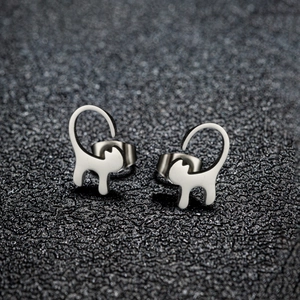 Macro shot of minimalist silver cat-shaped stainless steel stud earrings with hollow design