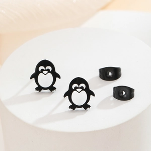 Macro shot of cute black penguin stud earrings with detailed cutouts and butterfly backings