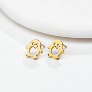 Close-up of golden penguin stud earrings featuring a hollow heart-shaped belly detail