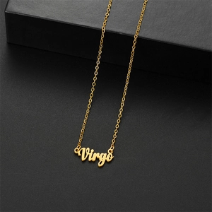 Primer plano del collar dorado del zodiaco Virgo con colgante de letras sobre fondo negro