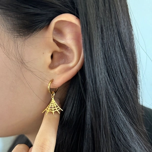 Boucles d'oreilles toile d'araignée dorées en acier sur modèle pour look Halloween