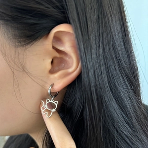 Gros plan de boucles d'oreilles chat minimalistes en argent portées par un mannequin pour taille