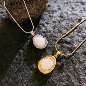 Elegante Halsketten mit ovalem Mondstein-Anhänger in Gold und Silber auf Schlangenkette