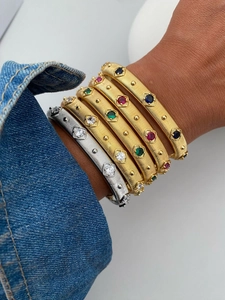 Macro shot of gold brushed metal bracelet with colorful gemstones in vintage palace style