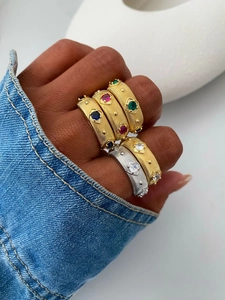 Detailed macro view of vintage brushed metal rings with colorful inlaid gemstones