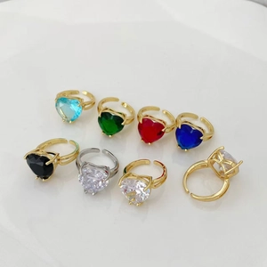 Dettaglio di anelli con zirconi a forma di cuore multicolore e fascia dorata regolabile