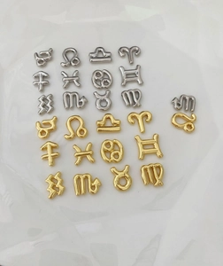 Macro detail of gold and silver zodiac charm pendants for DIY jewelry making sets