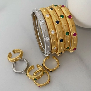 Vintage gold and silver brushed metal bangles and rings set with colorful gemstones