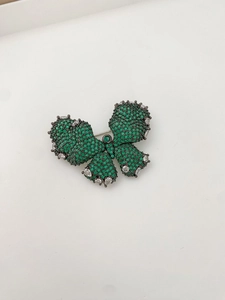Macro detail of butterfly brooch with green zircon inlay and vintage black metal finish