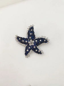 Détail de la broche étoile de mer luxueuse avec strass bleu foncé et pierres claires