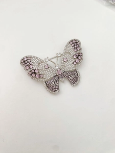 Detailed macro view of the butterfly brooch featuring pink and white pavé-set crystals