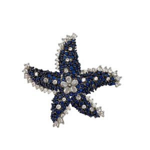 Élégante broche étoile de mer argentée avec strass bleus et détail floral blanc au centre