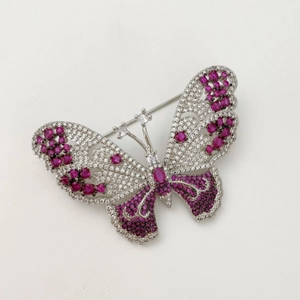 Elegant silver butterfly brooch with pink gemstones and white zircons on white backdrop