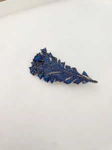 Detailed view of the dark blue crystal feather brooch with leaf shape and alloy plating