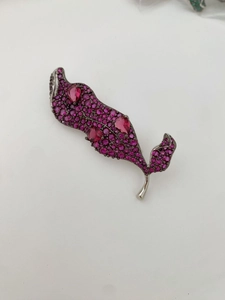 Détail macro de la broche feuille avec pavé de zircons roses et pierres en forme de poire