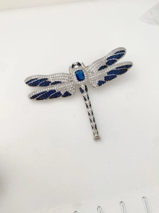 Détail d'une broche libellule en argent avec zircons bleus et ailes travaillées