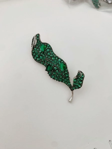 Vue détaillée de la broche feuille en argent avec zircons verts et pierres en poire