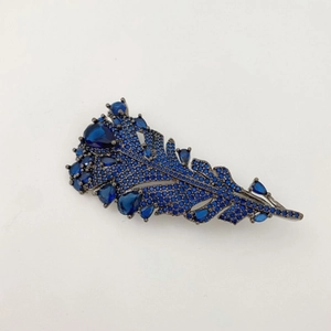 Elegant navy blue feather brooch featuring emerald-cut crystals on gun-black metal finish