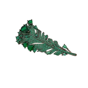 Luxurious feather brooch with deep green emerald crystals and dark metal base